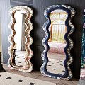 Decorative Scalloped Edge Mirrors With Floral Patterned Frames And Candle Holders On Checkerboard Floor