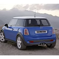 Blue Mini Cooper Two Door Car With White Roof And Silver Wheels In Mountain Landscape