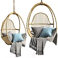 Stylish Rattan Hanging Chair with Blue and Gray Pillows and Cozy Blanket