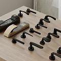 Various Black and Beige Door Handles with Electronic Locks on Wooden Table