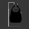 Black Quilted Handbag With Handles And Small Decorative Charm On Transparent Display Stand