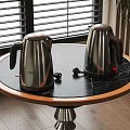 Stainless Steel Electric Kettles on Black Marble Round Tabletop with Window Background