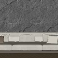 Light Colored Multi Seater Sofa With Cushions Against Dark Stone Wall And Wooden Floor