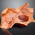 Orange Textured Surface Sculpture With Irregular Shape And Hollow Section On Dark Background