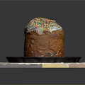 Traditional Sweet Bread With White Frosting And Colorful Sprinkles On Black Plate And White Mat