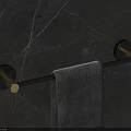 Bathroom Towel Rod with Black Metal and Gold Base Hanging Gray Towel on Marble Wall