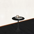 Black Round Side Table With White Cup And Book On Dark Wooden Floor Light Wall