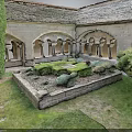 Ancient Stone Courtyard With Arched Portals Central Lawn Lush Bushes And Trees