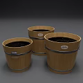 Three Decorative Wooden Planter Buckets With Metal Bands And Soil Inside