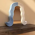 Modern Sculptural Wavy Two Tone Blue And White Mirror On Wooden Surface With Light Shadows