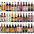 Various Colorful Condiment Bottles With Different Seasoning Labels In Kitchen