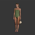 Woman Wearing Green One Piece Swimsuit Holding Straw Hat Against Gray Background