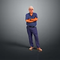 Senior Man in Blue Shirt and Blue Pants Standing With Arms Crossed Against Gray Background