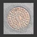 Square Metal Manhole Cover Featuring Intricate Circular Pattern And Traditional Symbols