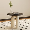 Modern Round Side Table With Black Top White Legs And Green Plant Vase On Books