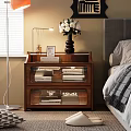 Wooden Nightstand With Glass Front Drawers Books And White Flowers Vase In Bedroom