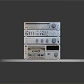 Stacked Electronic Audio Equipment With Knobs Buttons On White Round Platform