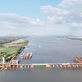 Massive Cable Stayed Bridge Under Construction With Tower Crane Spanning The Wide Calm River