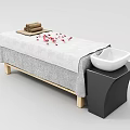 Spa Massage Bed with Rolled Towels Red Petals Gray Sheet White Bowl on Black Table
