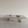 Modern Coffee Table with Marble Top and Curved Metal Base Featuring White Flowers Books and Tray