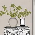 White Wave Pattern Vase Holding Green Foliage On Marble Table With Lamp And Curtain