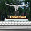 White Wavy Design Sculpture On Black Base With Trees And Lawn Outdoor