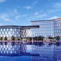 Modern Hotel Building Featuring Curved Glass Curtain Walls And Reflective Pool Under Blue Sky