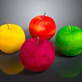 Four Colorful Apples in Yellow Red Pink and Green on Dark Background