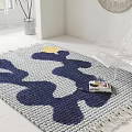Modern Square Rug with Blue White Wave Pattern Sun Design Near Transparent Chair and Book