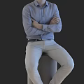 Man in blue shirt with arms crossed sitting on gray cylinder against black background