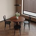 Interior View Of Dining Space With Round Wooden Table White Vase Flowers And Black Chairs