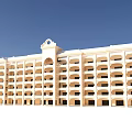 Multi Story Cream Colored School Building With Balconies Numerous Windows And Decorative Top