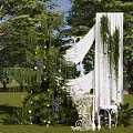Outdoor Photo Check in Spot With White Arch Green Vines Purple Flowers And Lawn Trees