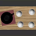Black Cast Iron Teapot with Red Mat on Wooden Tray and Four White Small Bowls