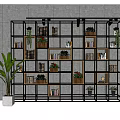 Black Metal Frame Bookcase With Multiple Shelves Plants Books And Decorations Against Gray Wall