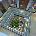 Spacious Shopping Mall Lobby With Glass Floor Central Green Plant Decorative Paintings And Modern Lighting