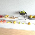 Fresh Assorted Fruits Display on White Countertop with Black Stand Bowls and Wooden Floor