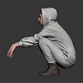 A Man Wearing Gray Hoodie And Gray Pants Squatting On Black Floor With Gray Background