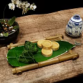Traditional Chinese Zongzi and Mooncakes on Reed Leaves with Bamboo Tray and Porcelain Vase
