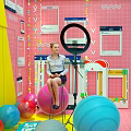 Public Office Space Featuring Pink Yellow Walls Picture Frames Colorful Exercise Balls And Ring Light