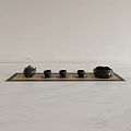 Black Tea Set With Teapot Three Cups And Bowl On Tray Over White Marble Countertop