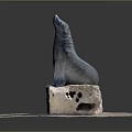 Detailed Seal Statue Perched On Weathered Stone Base With Cobblestone Pavement
