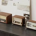Vintage Wooden Radios Arranged In Three Sizes On Black Table With Retro Wall Decor