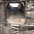 Ruined Stone Structure Interior With Metal Archway Broken Steps And Gravel Ground