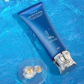 Blue Latitude Skincare Tube With White Flowers In Clear Container And Blue Water Ripple Background