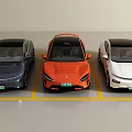 Three Electric Cars In Blue Orange White Colors Parked In Parking Lot