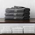 Soft Stacked Grey And White Towels With Striped Accents On Wooden Surface