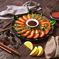 Delicious Grilled Shrimp with Fresh Coriander Leaves Lemon Slices Sauce and Spices on Black Plate