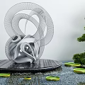 Metallic Spiral Garden Sculpture On Black Platform With Water Lily Pads And Shaped Green Tree