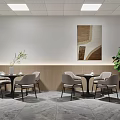 Modern Office Lounge Area With Round Tables Chairs Wall Artwork Green Plant And Ceiling Lights